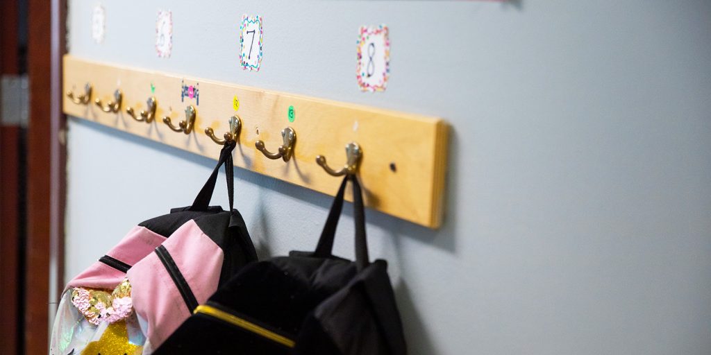 Wall rack with backpacks hanging up.